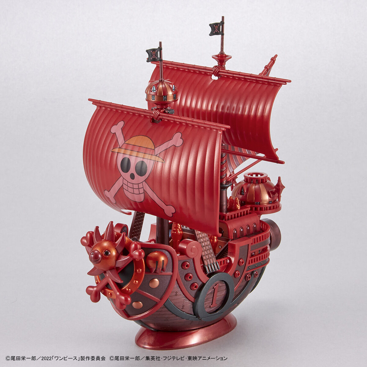 One Piece - Thousand Sunny - RED FILM Special - Grand Ship Collection Model Kit (Bandai), Metallic red color scheme inspired by the film "ONE PIECE FILM RED", includes character plates of the Straw Hat Pirates in movie costumes, display base and sea surface effect included, from Nippon Figures.